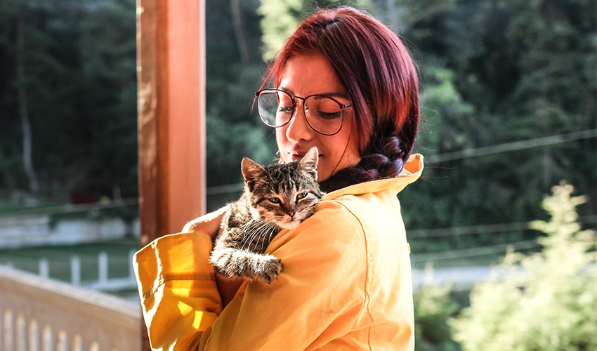 Jeune femme portant un chat dans ses bras